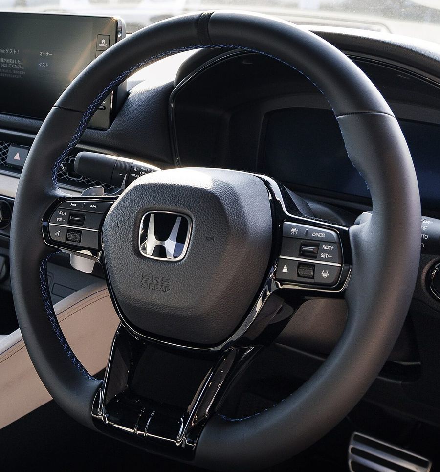 Detail crop of the Prelude steering wheel and its physical buttons.