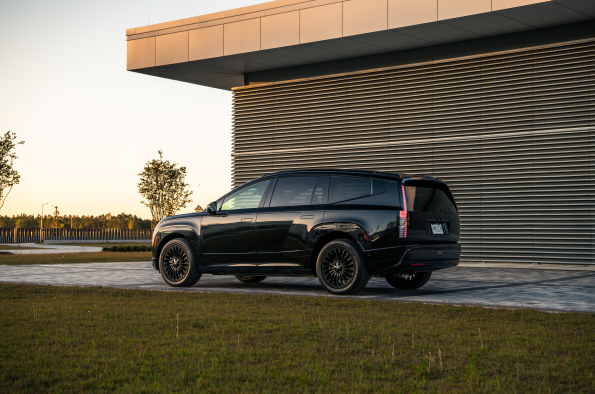 2026 Hyundai Ioniq 9 Calligraphy Black Ink, rear three-quarter view parked outside a modern building.