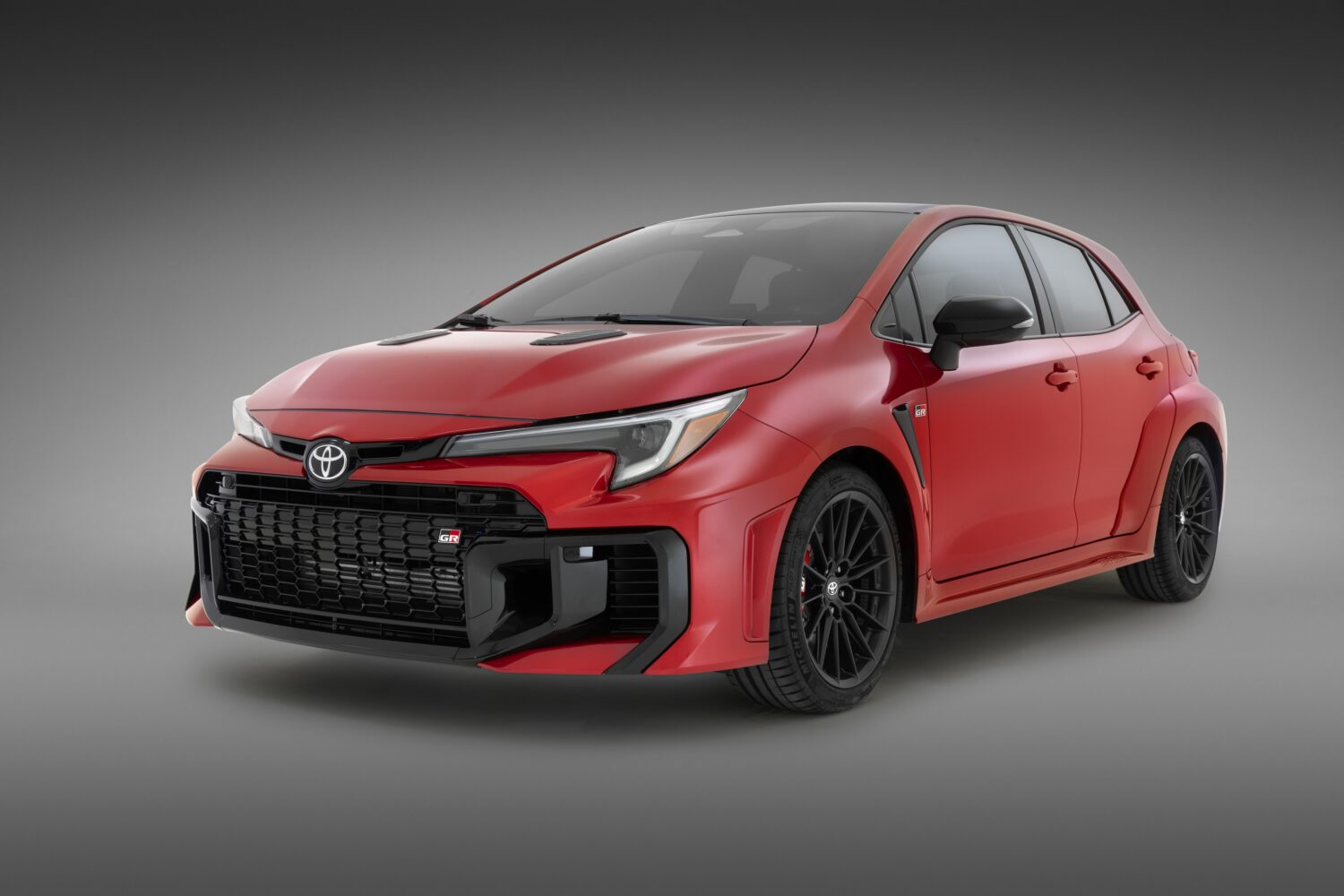 2026 Toyota GR Corolla in Supersonic Red, studio front three-quarter view.