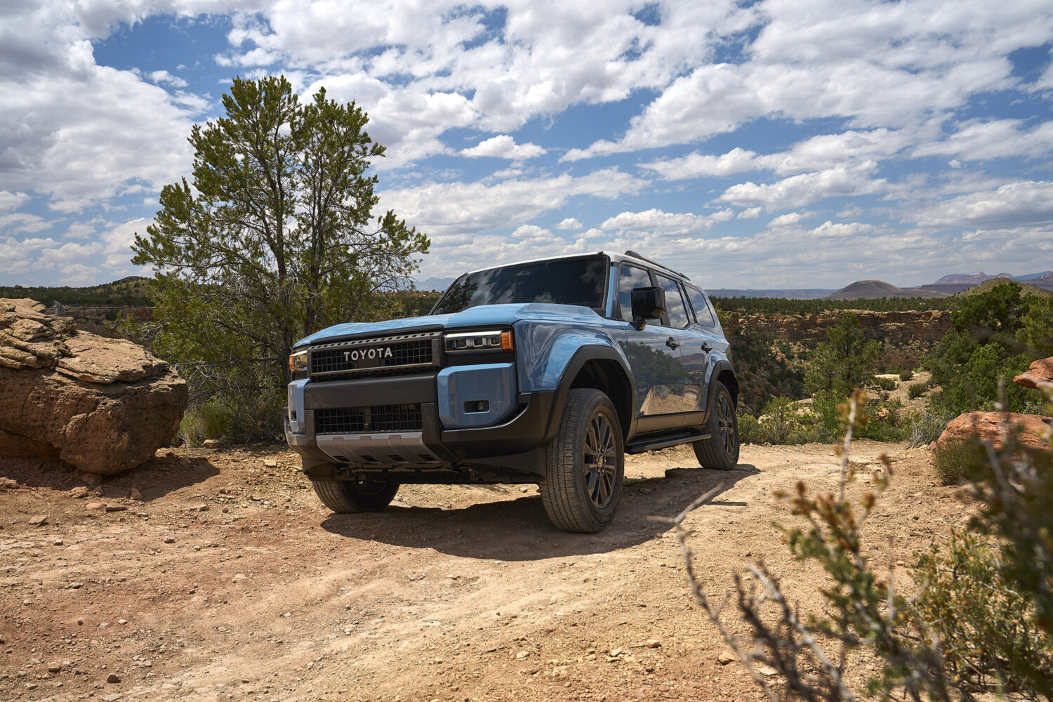 2026 Toyota Land Cruiser off-road, climbing rocky terrain.