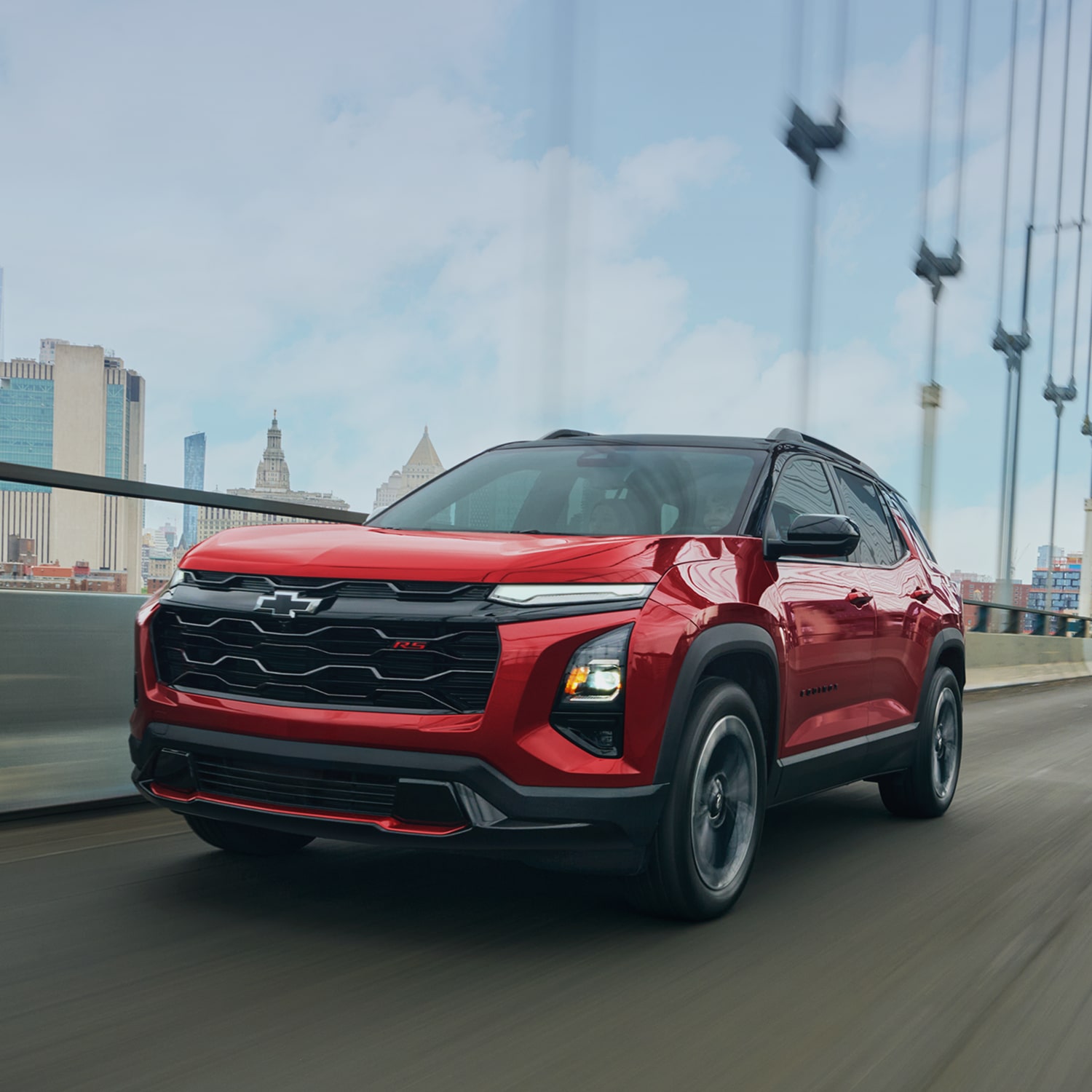 2027 Chevrolet Equinox RS in red, driving on a city bridge.