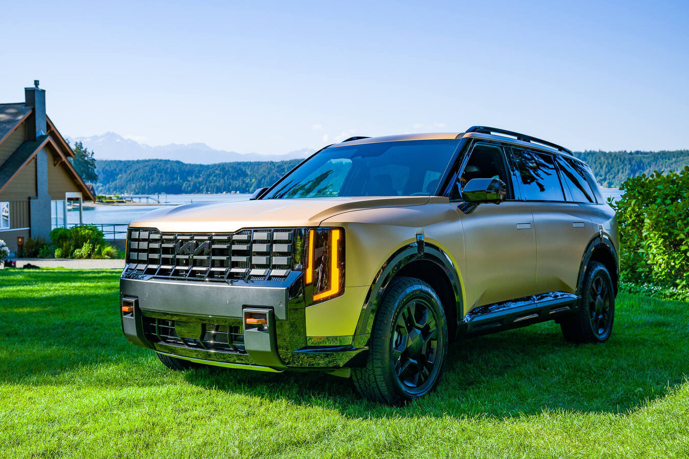 2027 Kia Telluride X-Pro front three-quarter view parked on grass near a lake, official Kia press photography.
