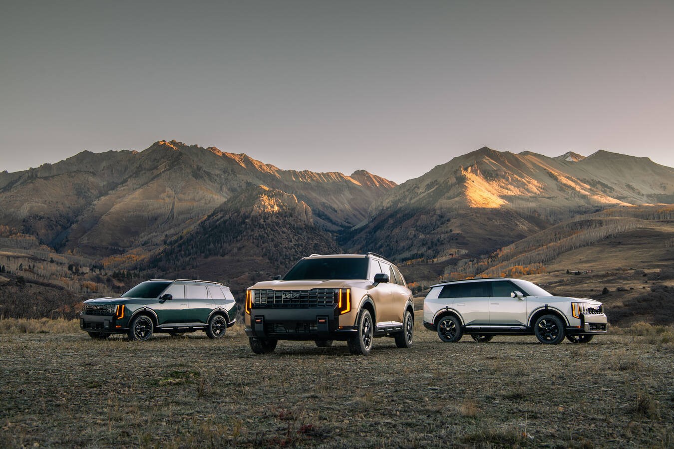 2027 Kia Telluride lineup of three trims in different exterior colors parked in a mountain landscape, official Kia press photography.