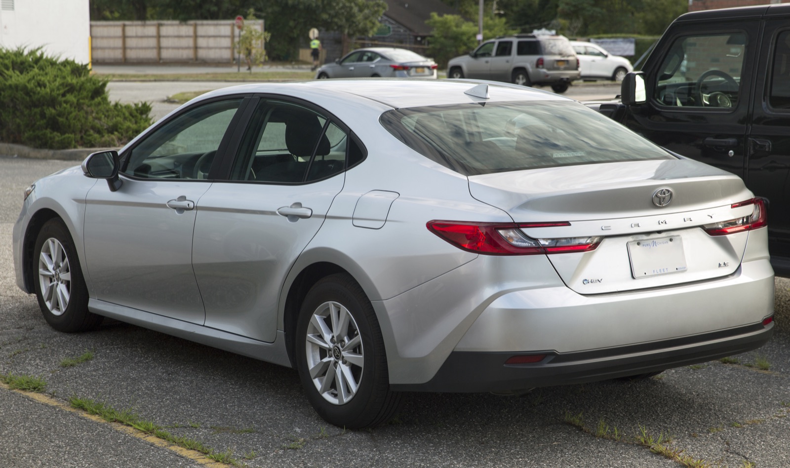 2027 Toyota Camry Hybrid LE, rear three-quarter view, real photograph.