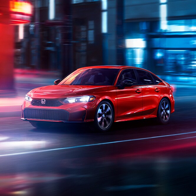 2026 Honda Civic Sedan, front three-quarter at night, official Honda press photograph