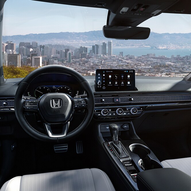2026 Honda Civic Sedan interior overlooking a city skyline, official Honda press photograph