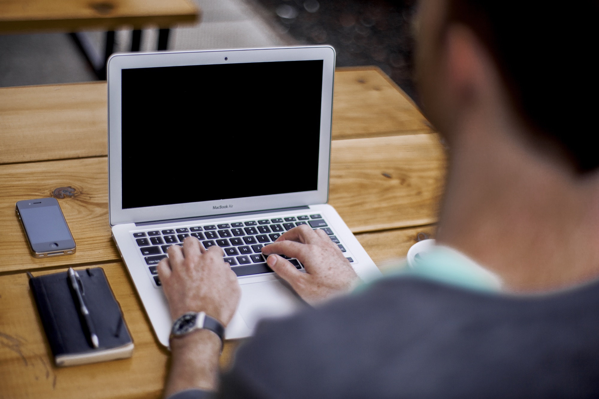 A person typing on a laptop keyboard, real photograph.