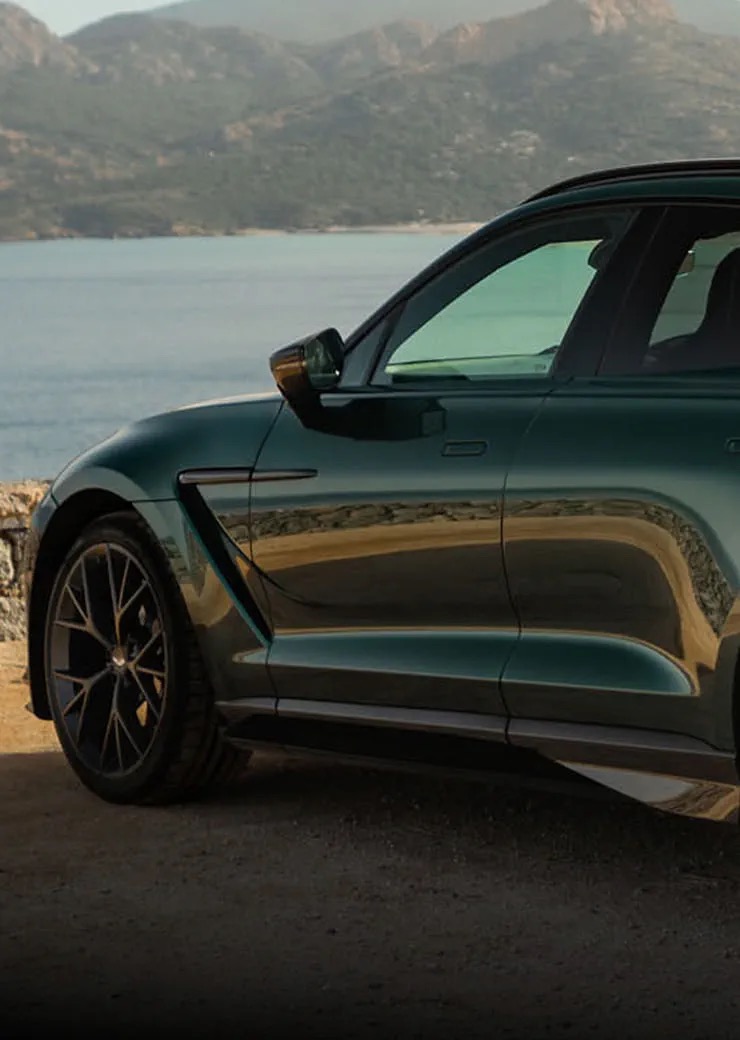 Side profile of the Aston Martin DBX707 parked near a coastal cliff.