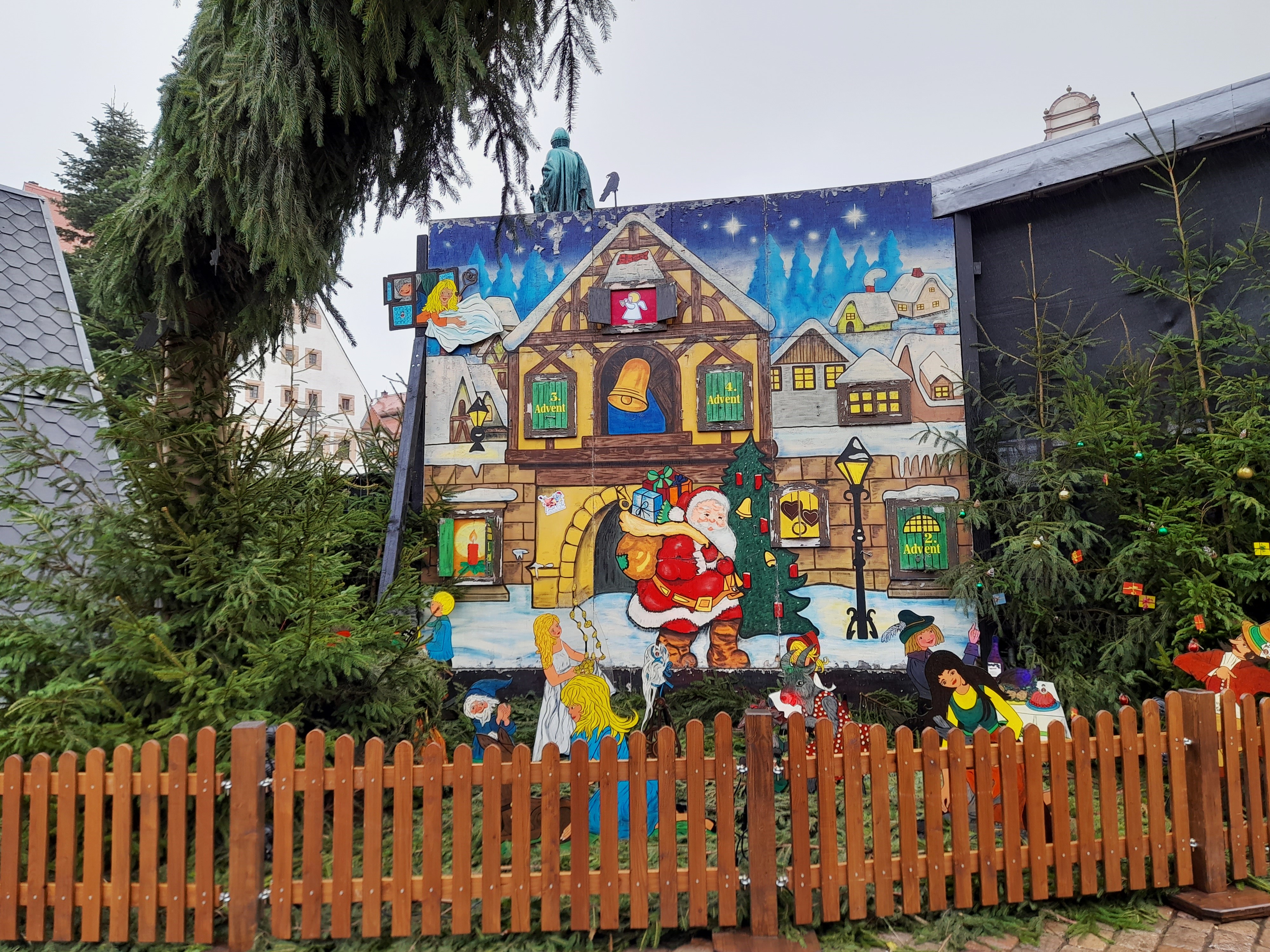 A large illuminated wooden Adventskalender display at a German Christmas market, a real photograph.