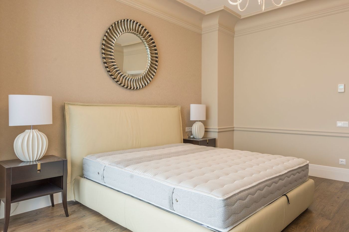Bedroom with a mattress on an upholstered bed frame and a lamp on the nightstand