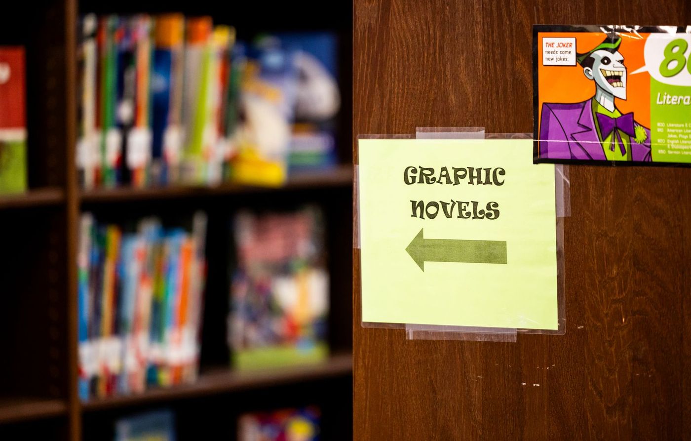 A library shelf area with a sign pointing to graphic novels