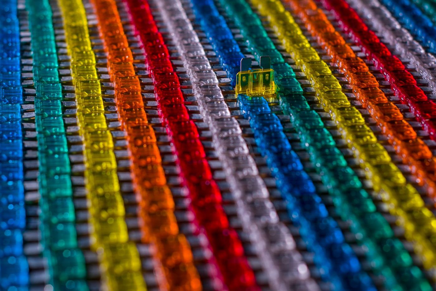 Rows of colored automotive blade fuses, the kind a hardwire kit taps into.