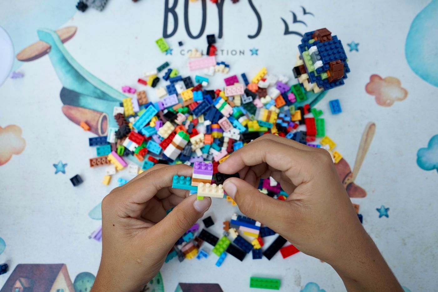 Hands sorting colorful LEGO bricks on a table