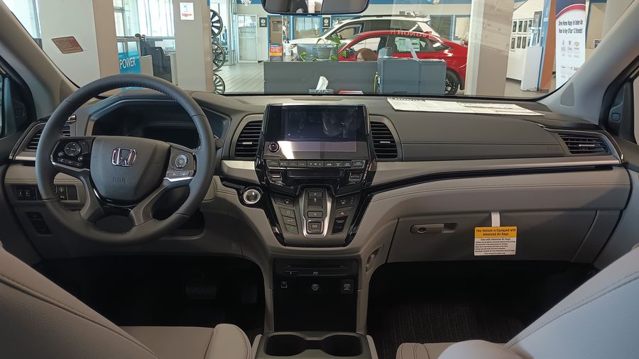 2023 Honda Odyssey cockpit: steering wheel, center touchscreen and push-button gear selector.
