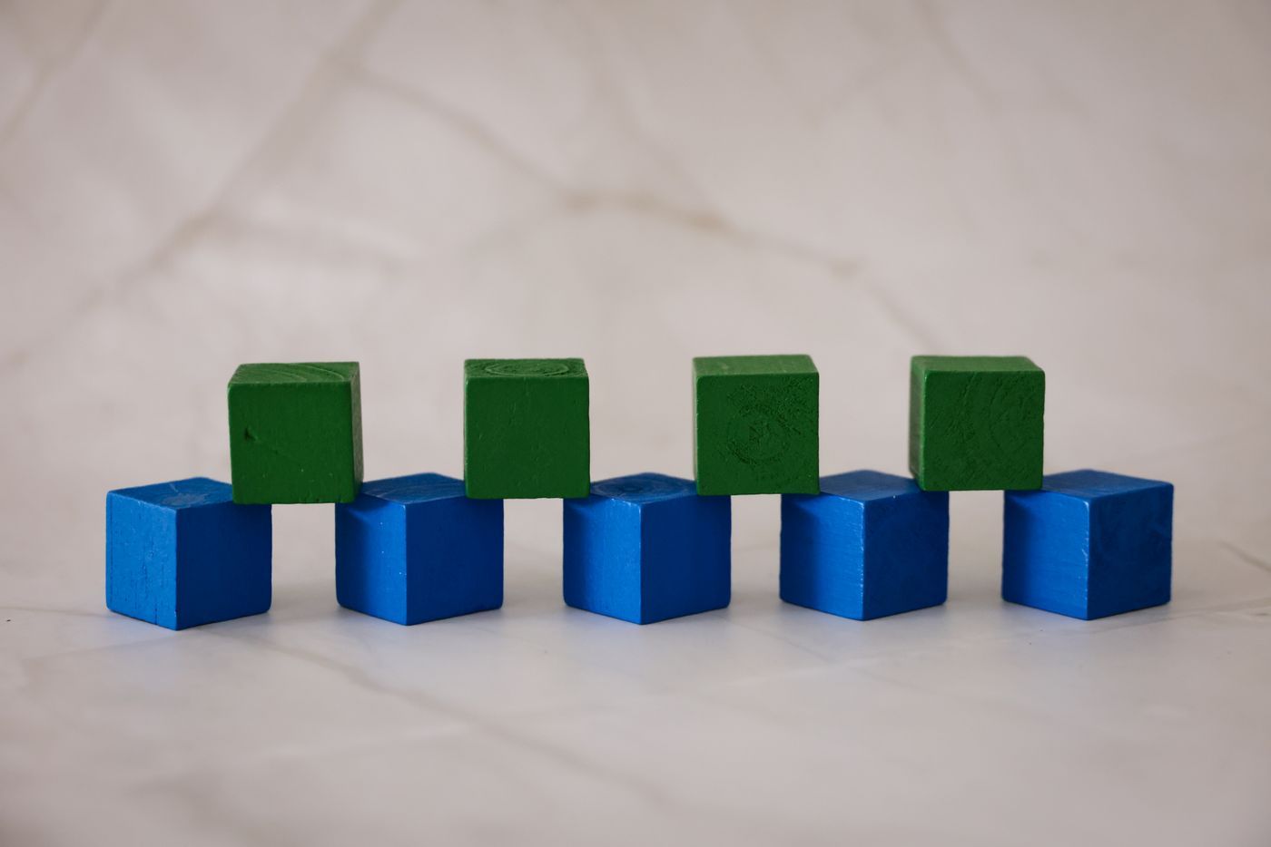 Wooden blocks stacked in a row on a marble surface