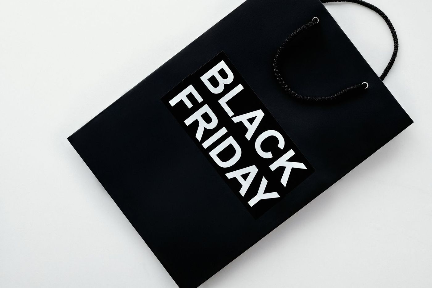 Black paper shopping bag with large white "Black Friday" lettering
