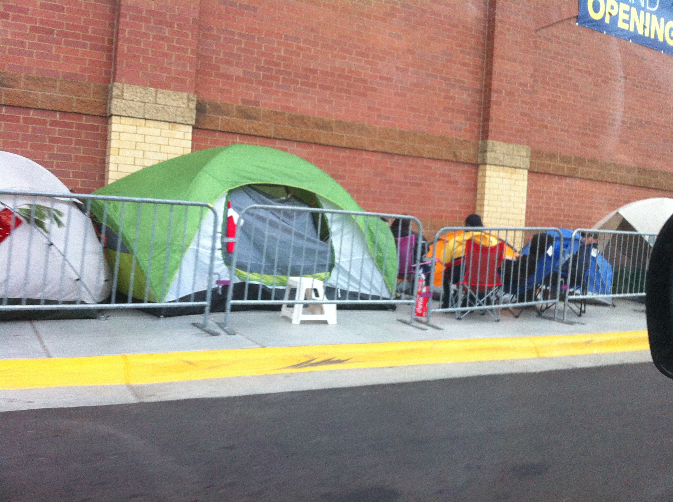 Shoppers camped in tents outside a Best Buy overnight ahead of Black Friday, real photograph.
