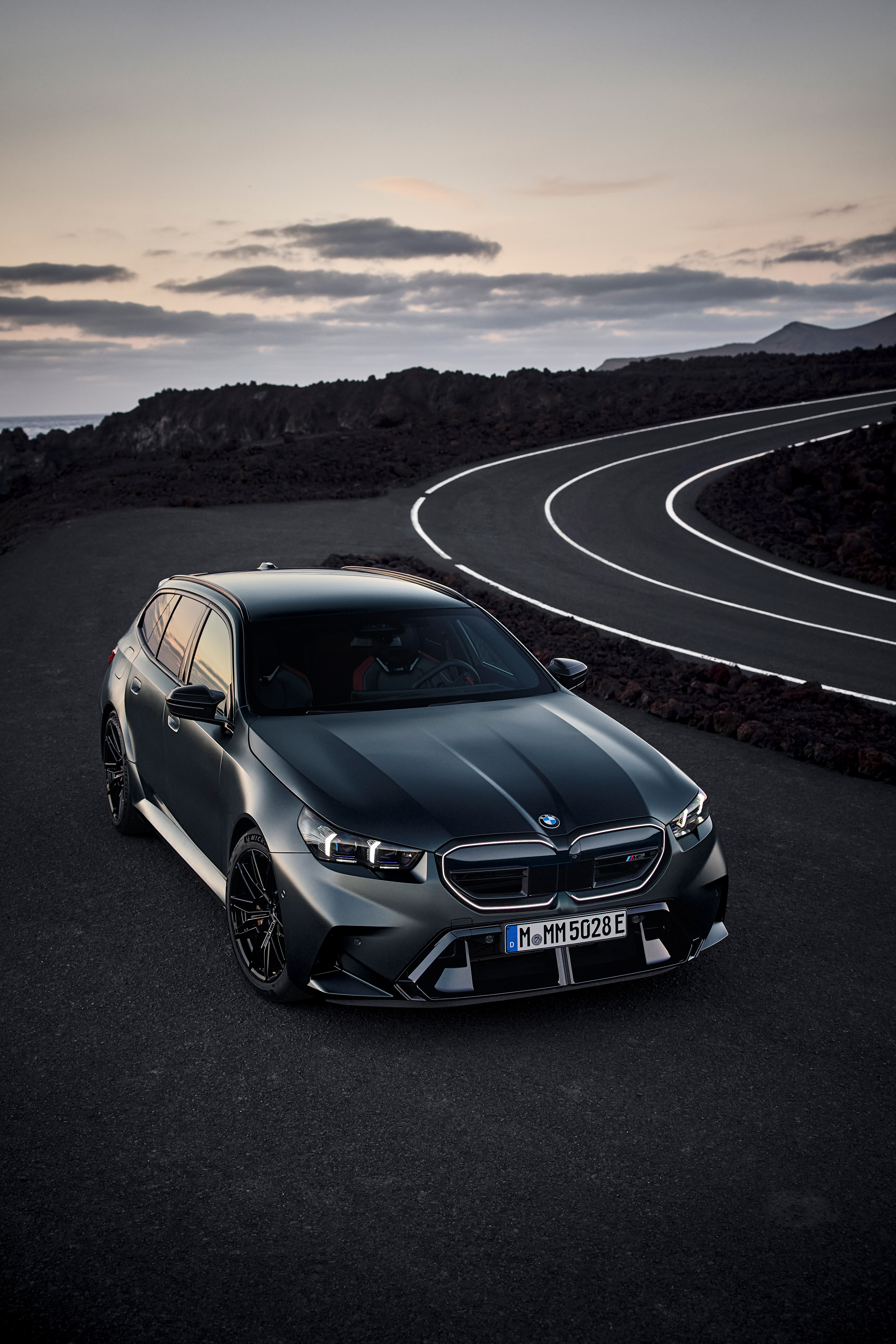 Front three-quarter view of the BMW M5 Touring on a coastal road.