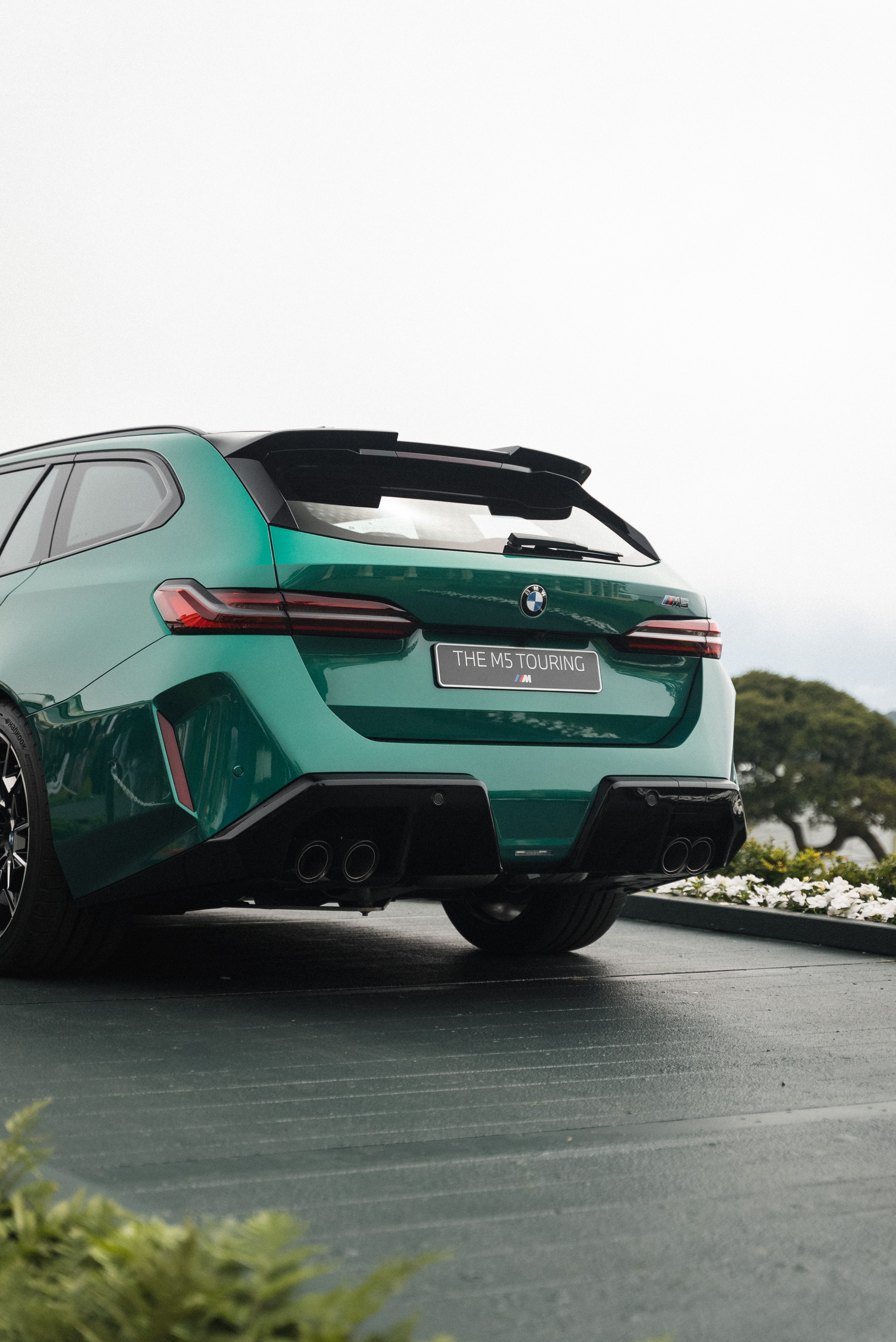 Rear view of a green BMW M5 Touring, badged 'THE M5 TOURING'.
