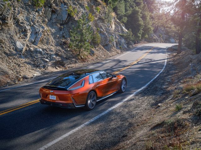 An orange Cadillac Celestiq driving on a country road.