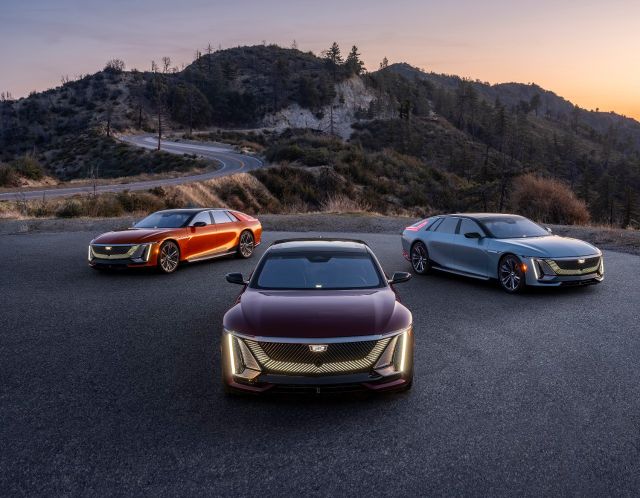 Three Cadillac Celestiq sedans in different colorways, parked on a mountain road at dusk.