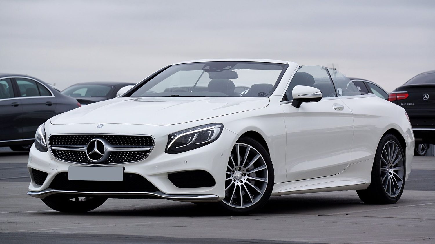 A white convertible with the roof down, parked outdoors.