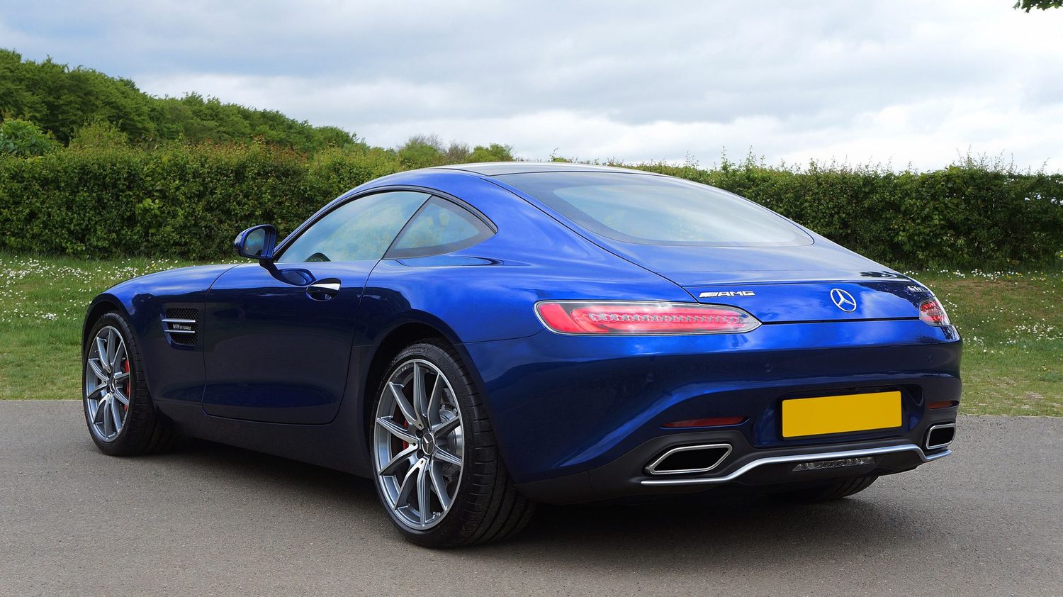 A blue two-door sports coupé with a long bonnet and a roofline sloping into the tail.