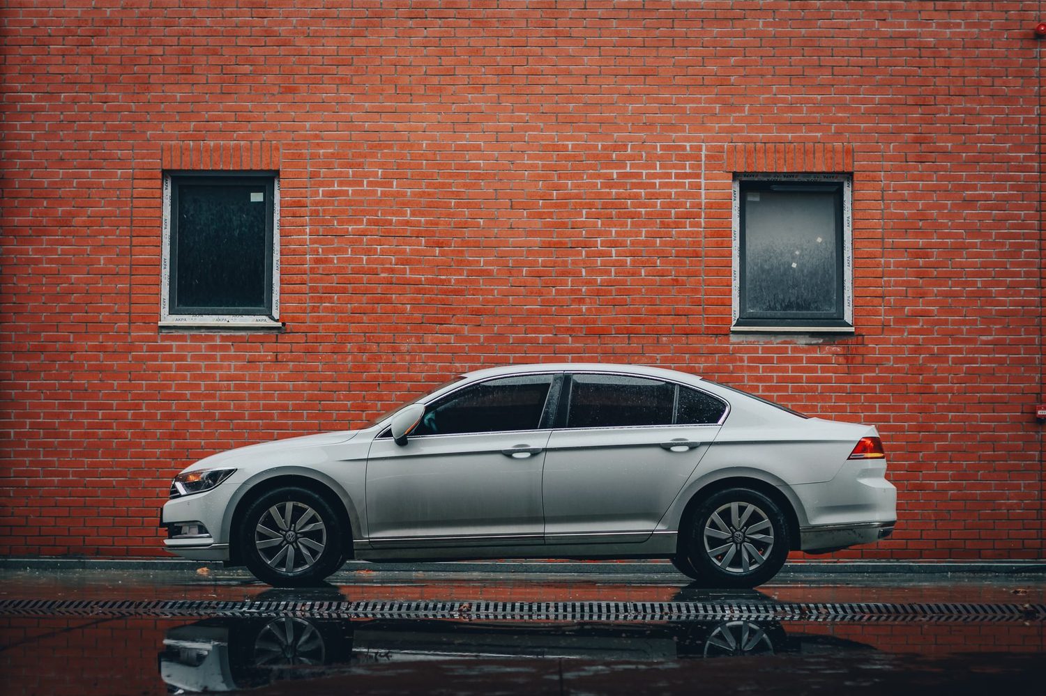 A silver sedan photographed from the side, showing the three-box profile.