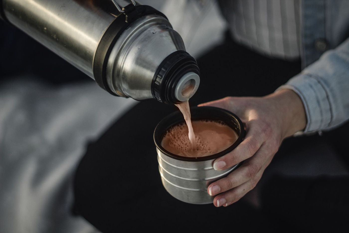 Pouring a hot drink from a steel thermos into its cup
