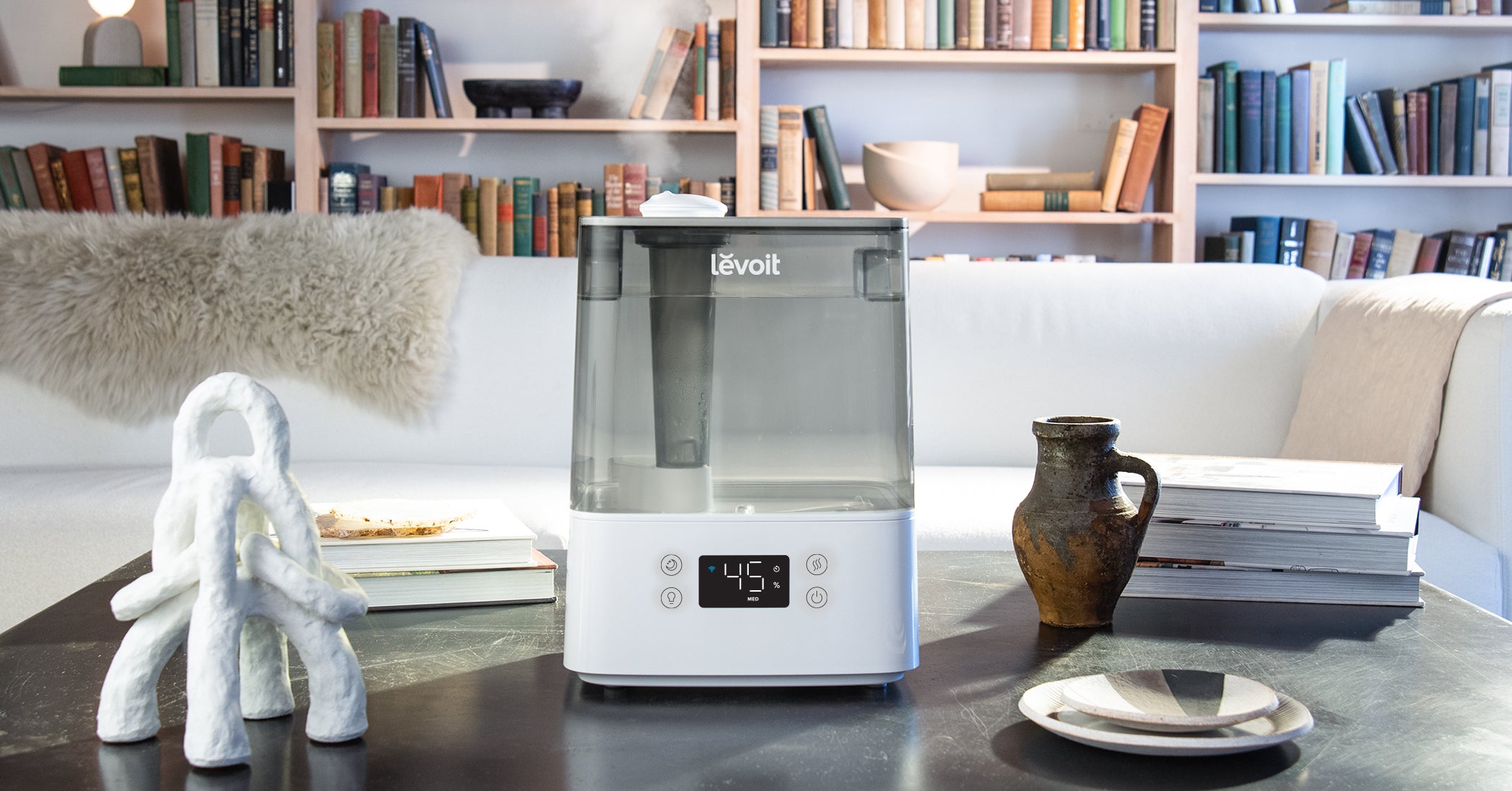 A cool mist ultrasonic humidifier on a living room table.