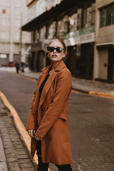 woman wearing burnt sienna wool coat on city street fall