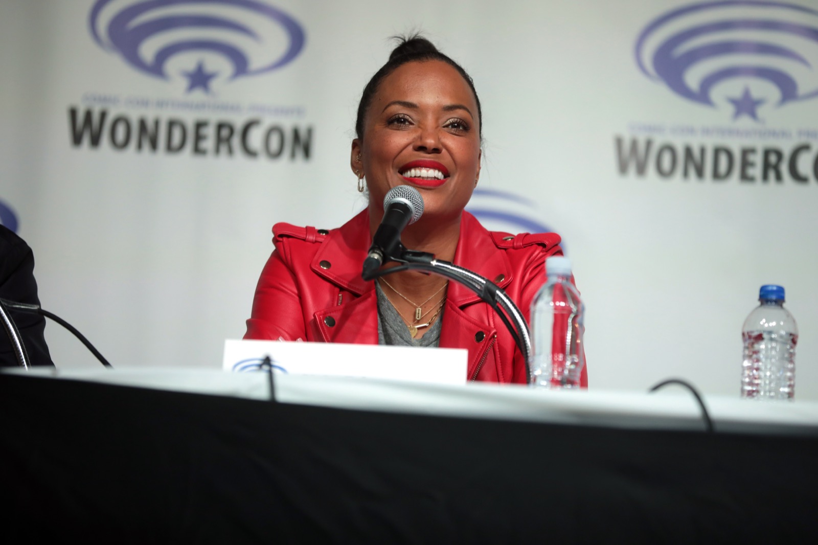 Aisha Tyler wearing a red leather jacket at WonderCon 2019