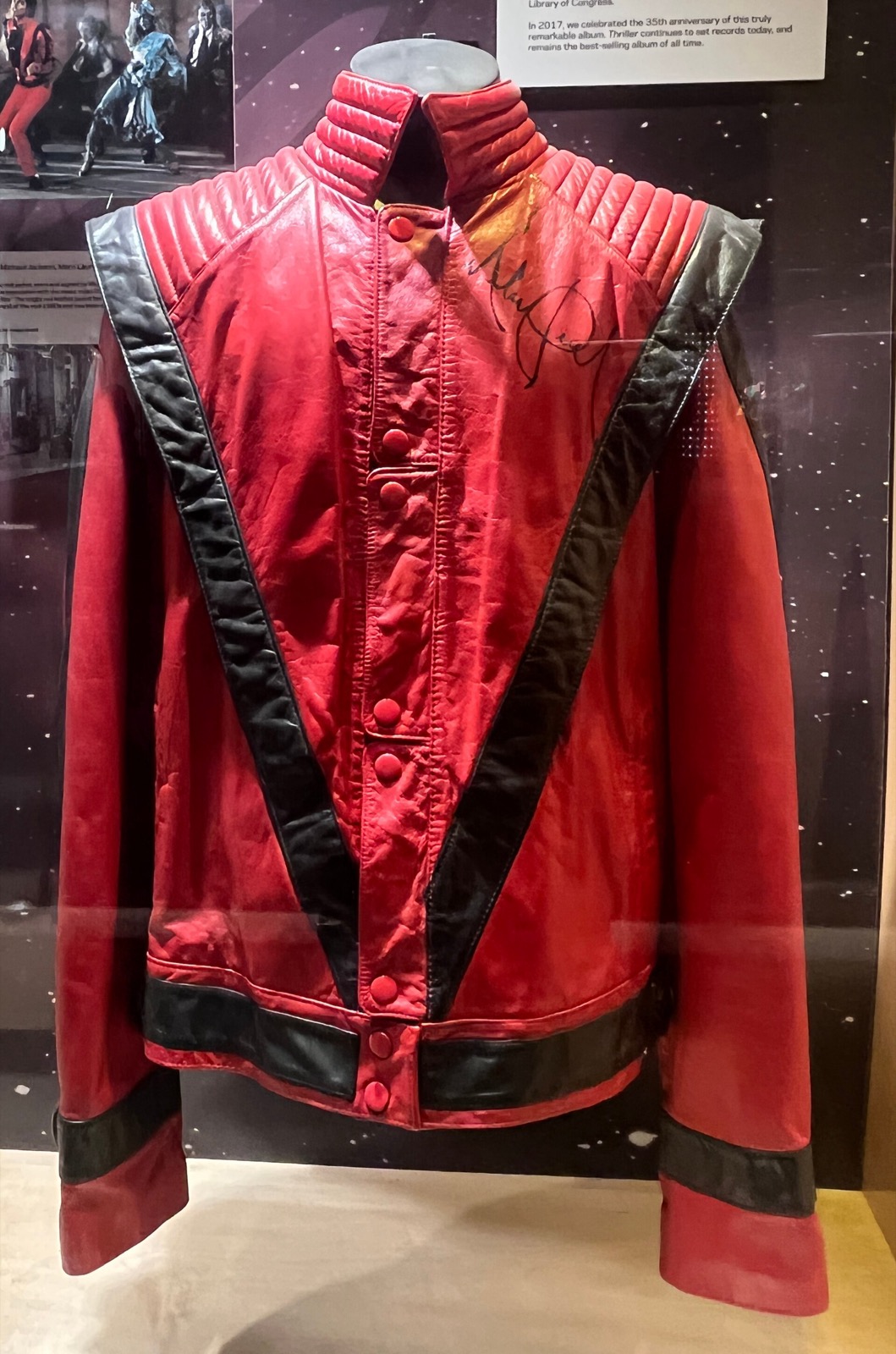 Close view of the red and black leather Thriller jacket's V-striped front on display at the Grammy Museum