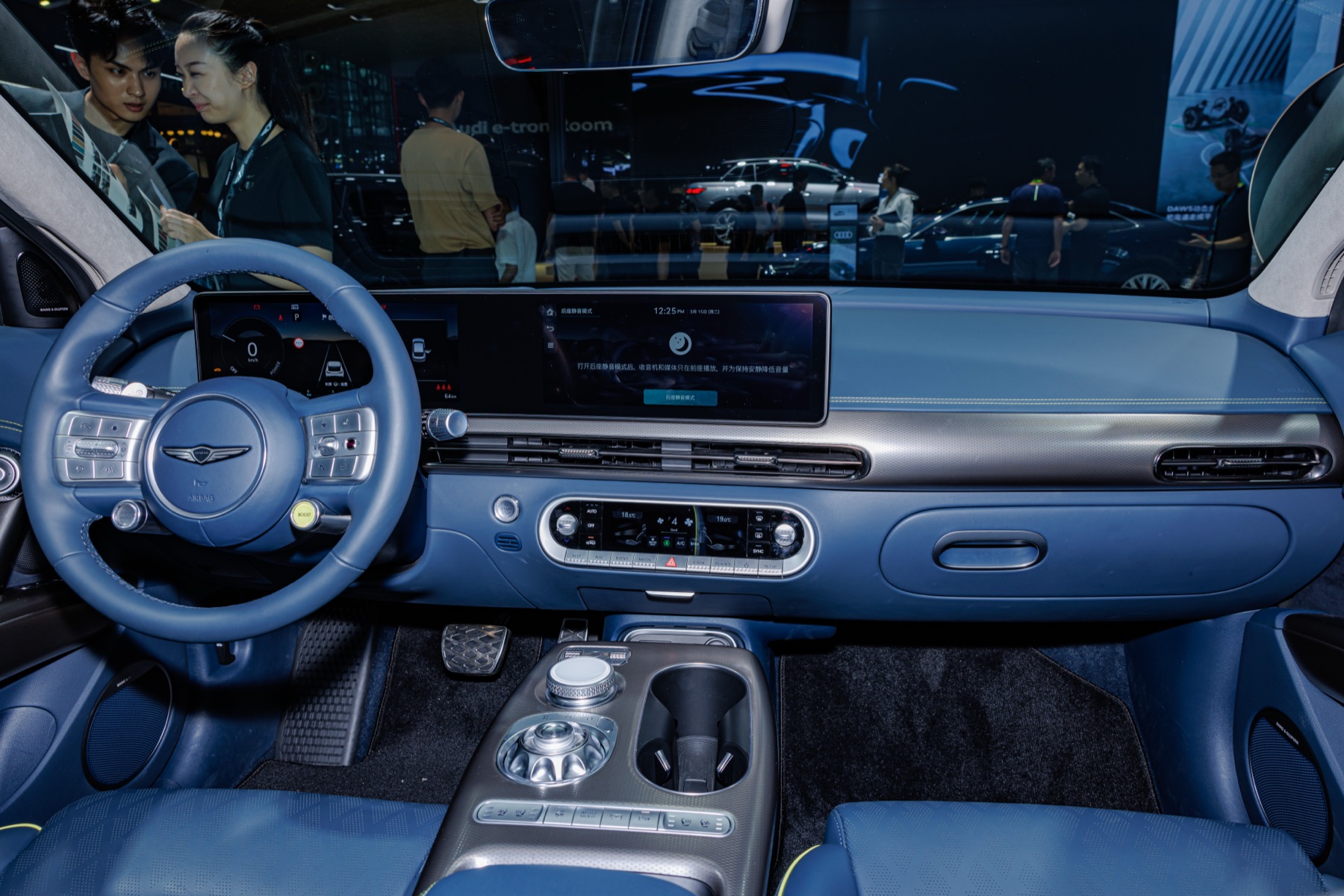 Genesis GV60 interior, dashboard and dual screens with steering-wheel Boost button, auto show photography.