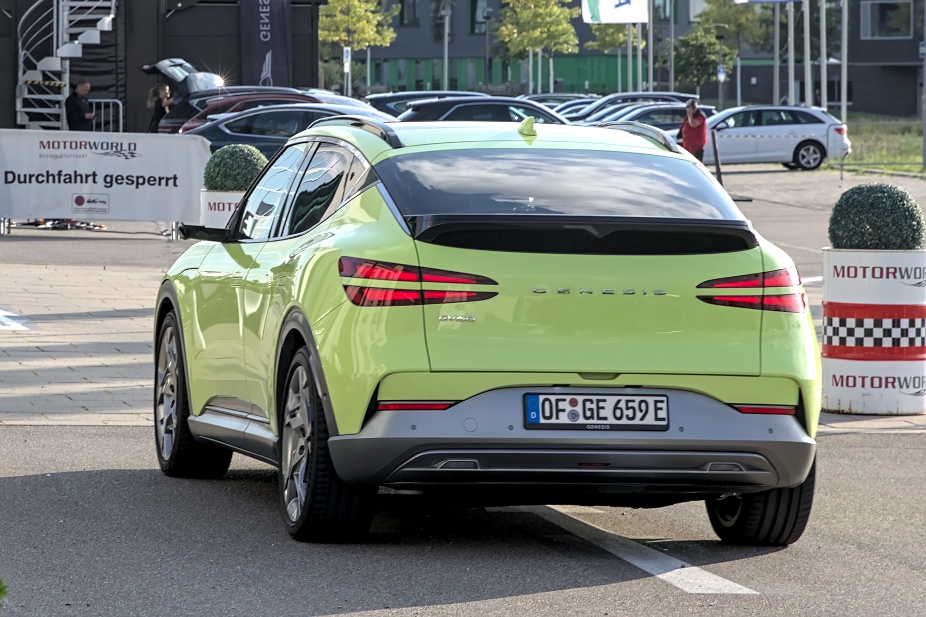 Genesis GV60 in a light green finish, rear three-quarter view.