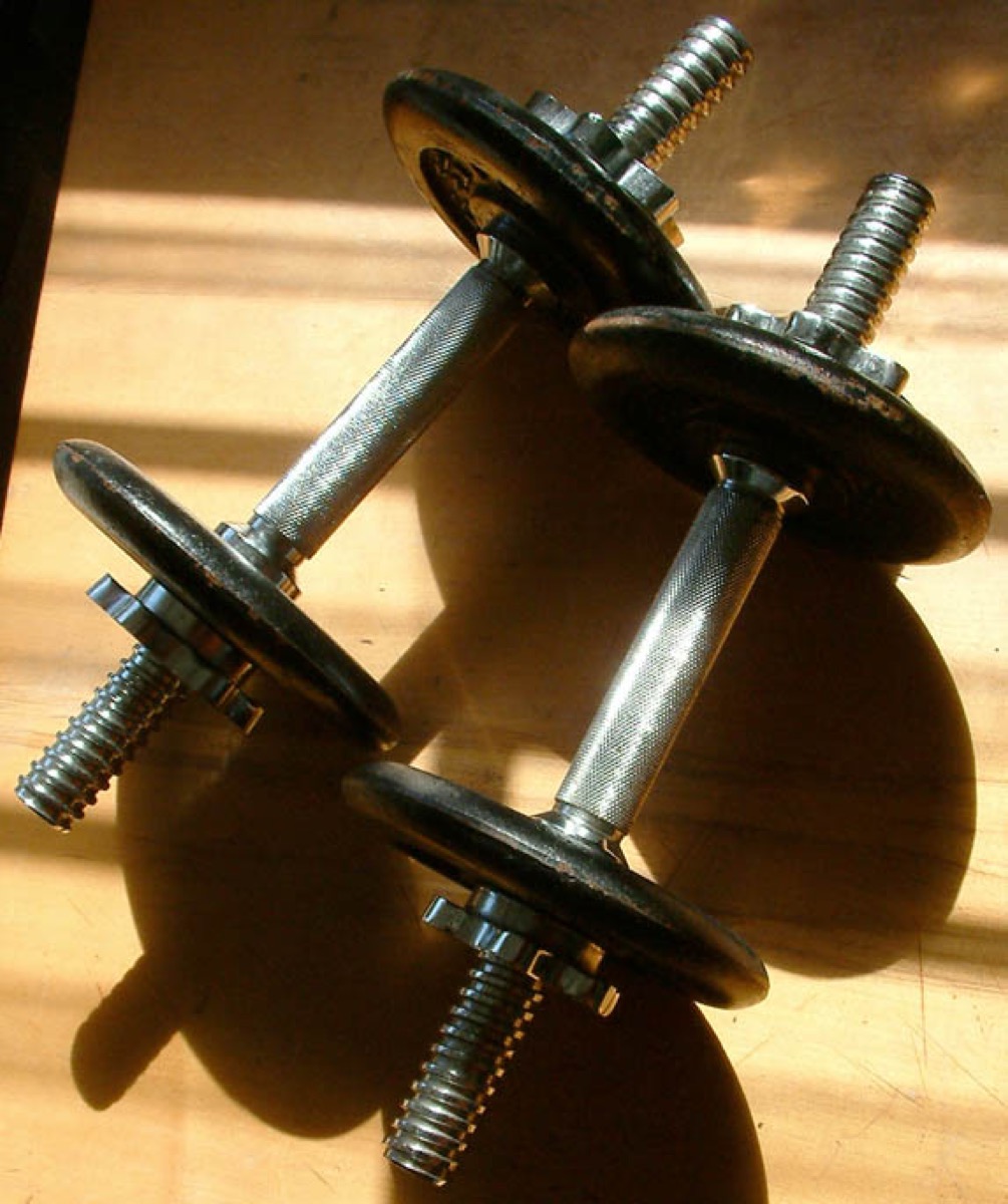 A pair of adjustable dumbbells on the floor