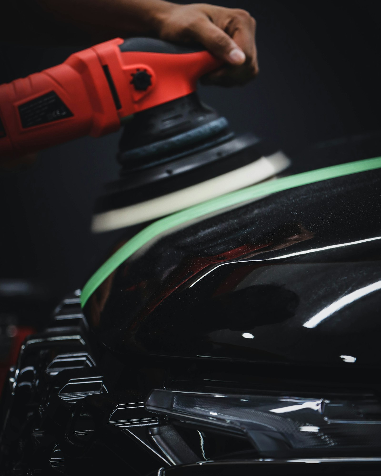A red and black dual-action power polishing tool.