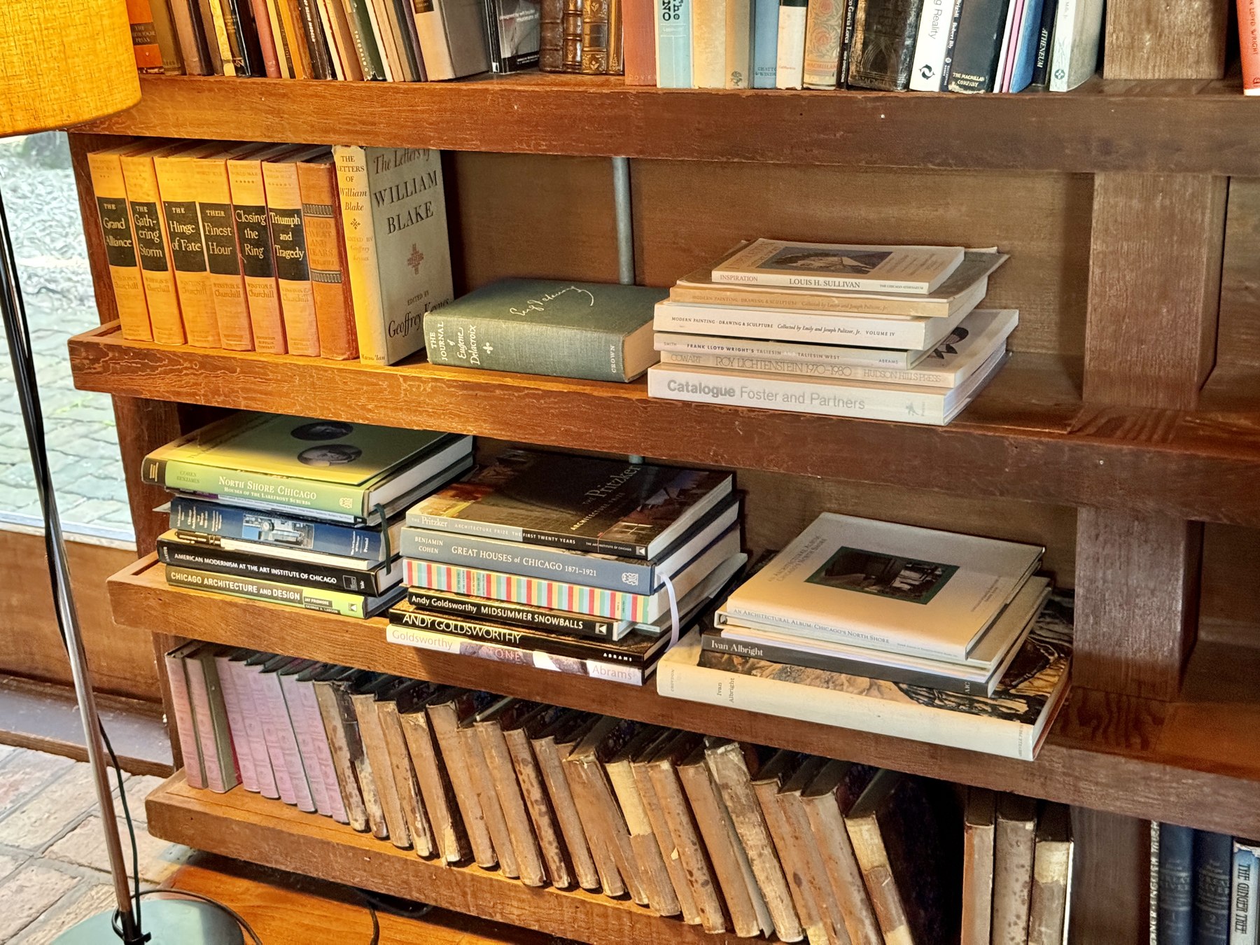 A real curated bookshelf with architecture books and personal objects