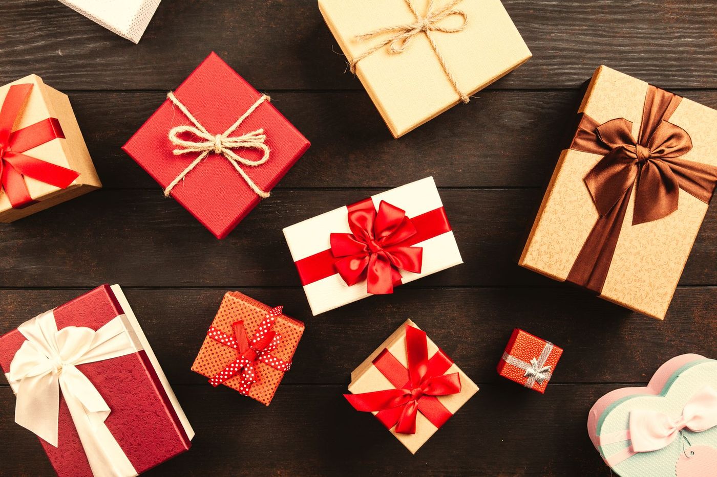 Wrapped holiday gifts laid out on a dark wooden table