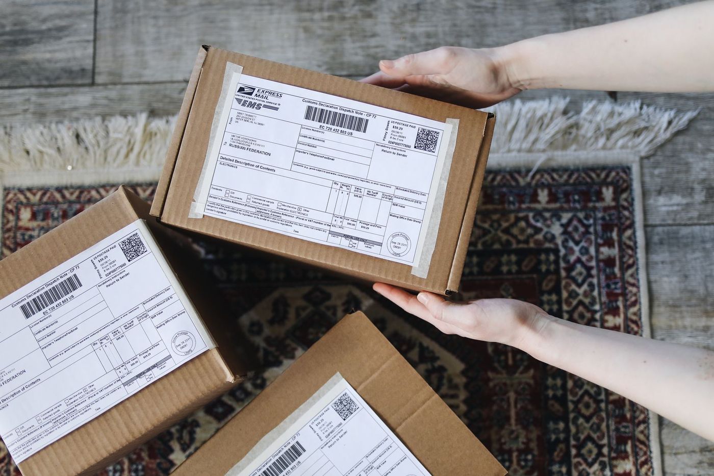 Hands holding a shipping box with a return label