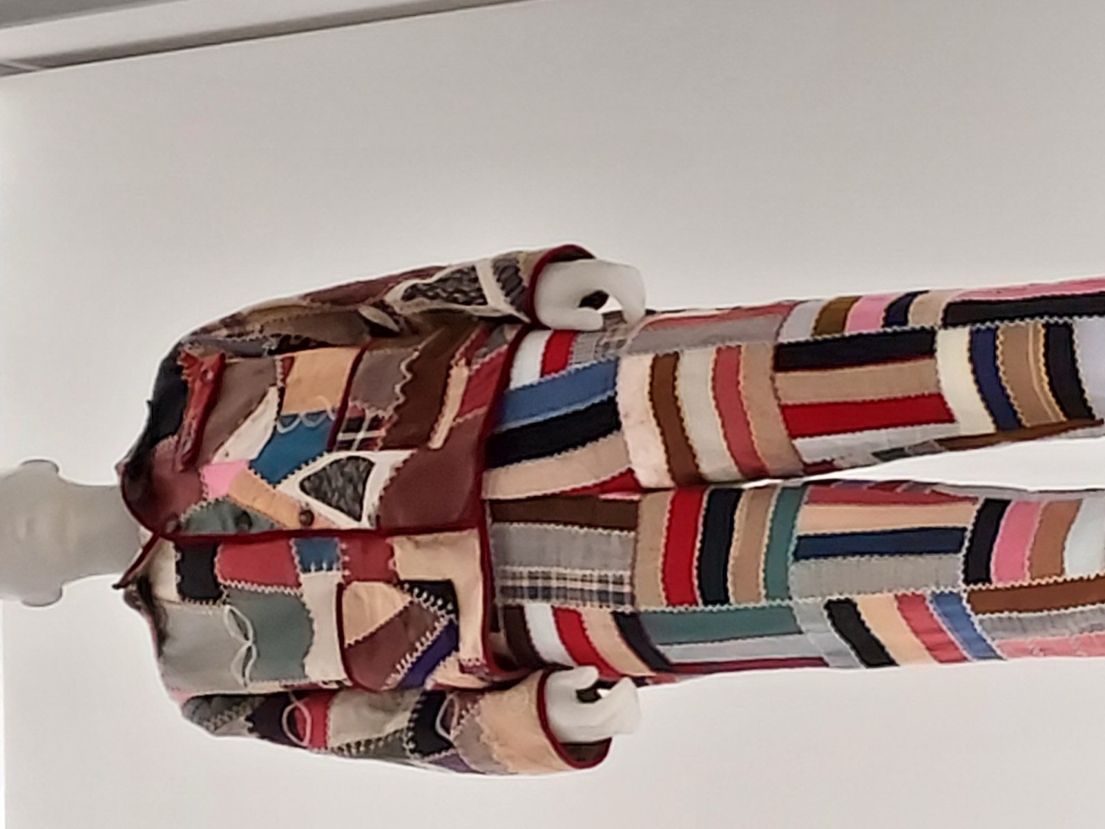 A Bode garment made from patchworked antique quilting fabric, displayed at the Met's In America: An Anthology of Fashion exhibition, a real photograph.