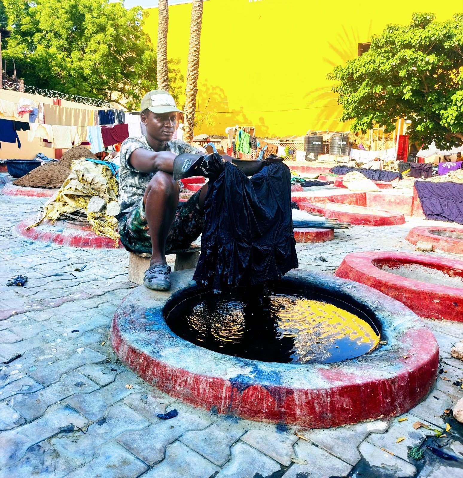 A person hand-dyeing fabric using the tie-dye technique, a real photograph, referencing Online Ceramics' signature tie-dye and hand-drawn graphics.