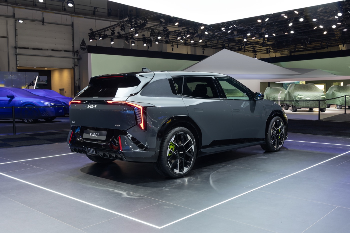 Kia EV4 GT, three-quarter rear view, official Kia press photography from a Kia motor show stand.