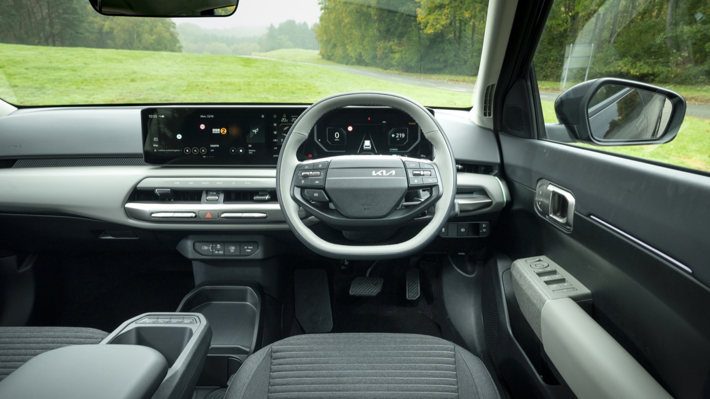 Kia EV4 interior, driver's view showing digital instrument cluster, official Kia press photography.