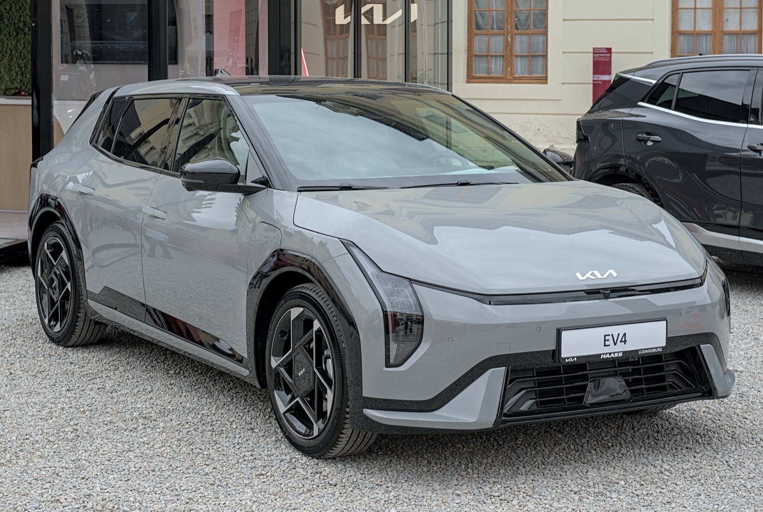 Kia EV4 GT-Line in grey, three-quarter front view, real photograph.