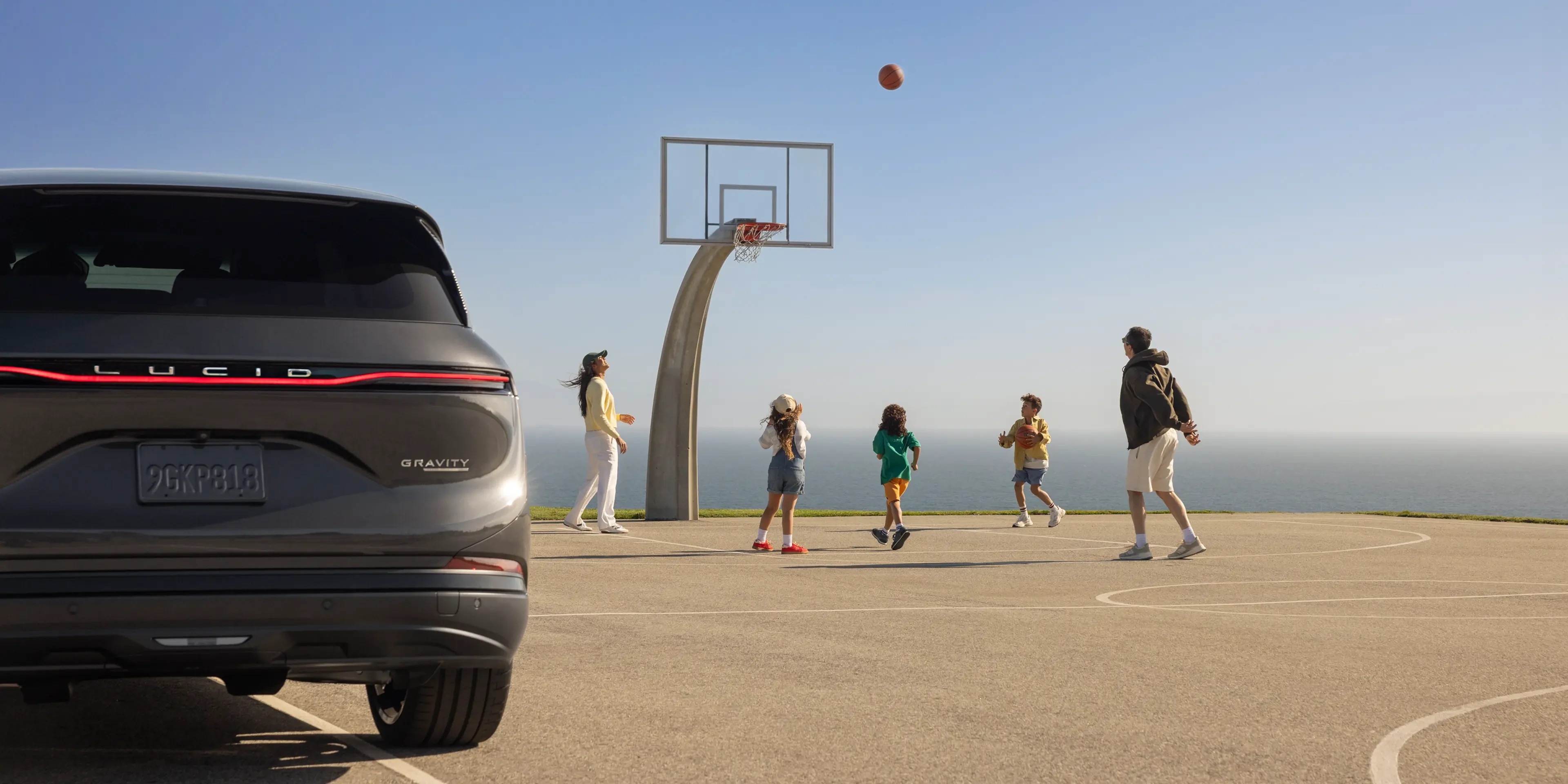 Lucid Gravity parked at an outdoor basketball court, official press photograph.