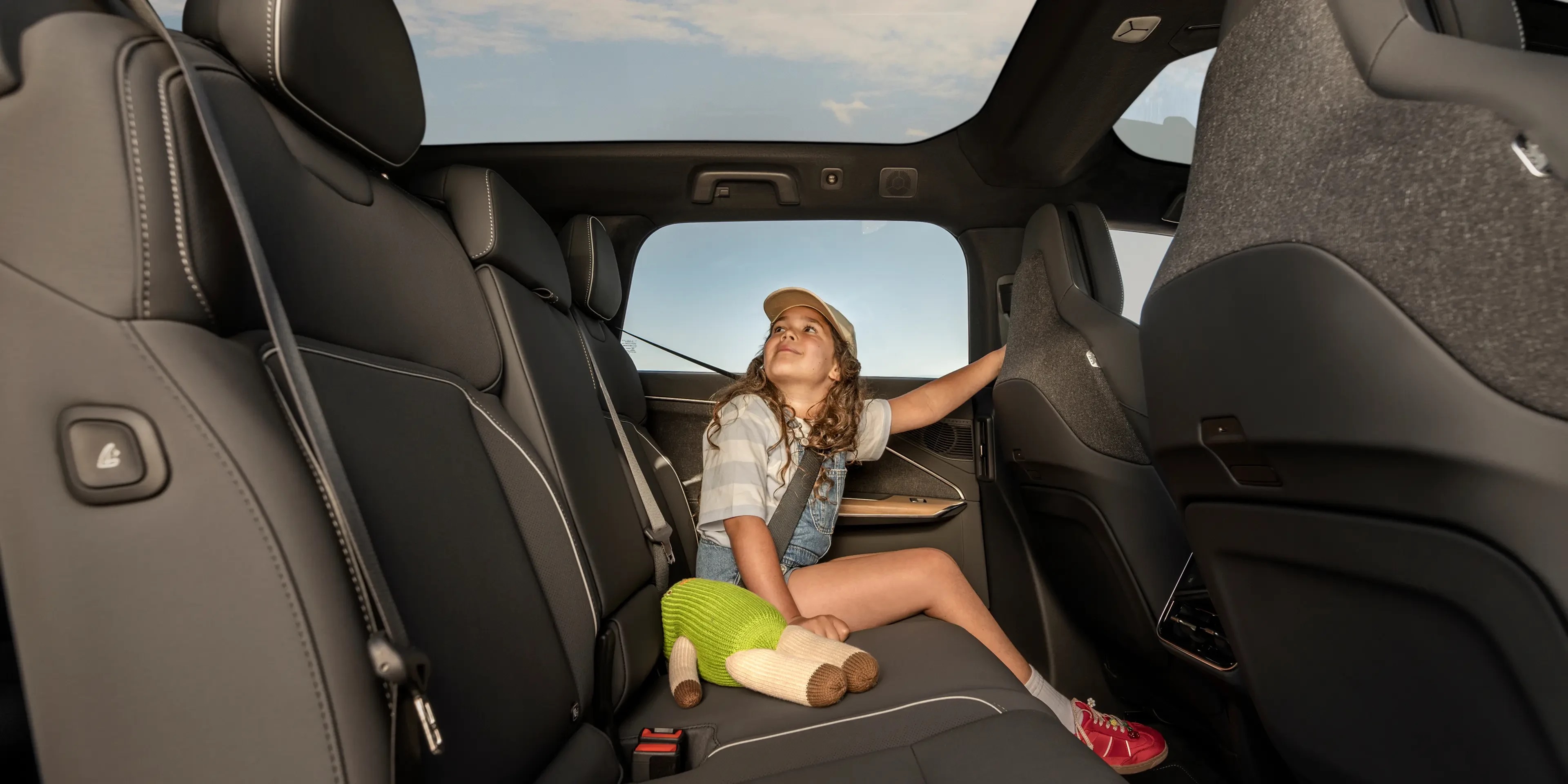 Lucid Gravity second-row interior, glass canopy roof and panoramic view, official press photograph.
