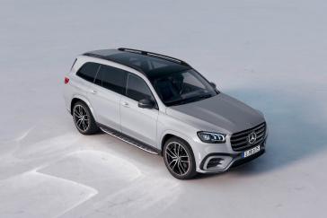 Mercedes-Benz GLS driving through a desert landscape.