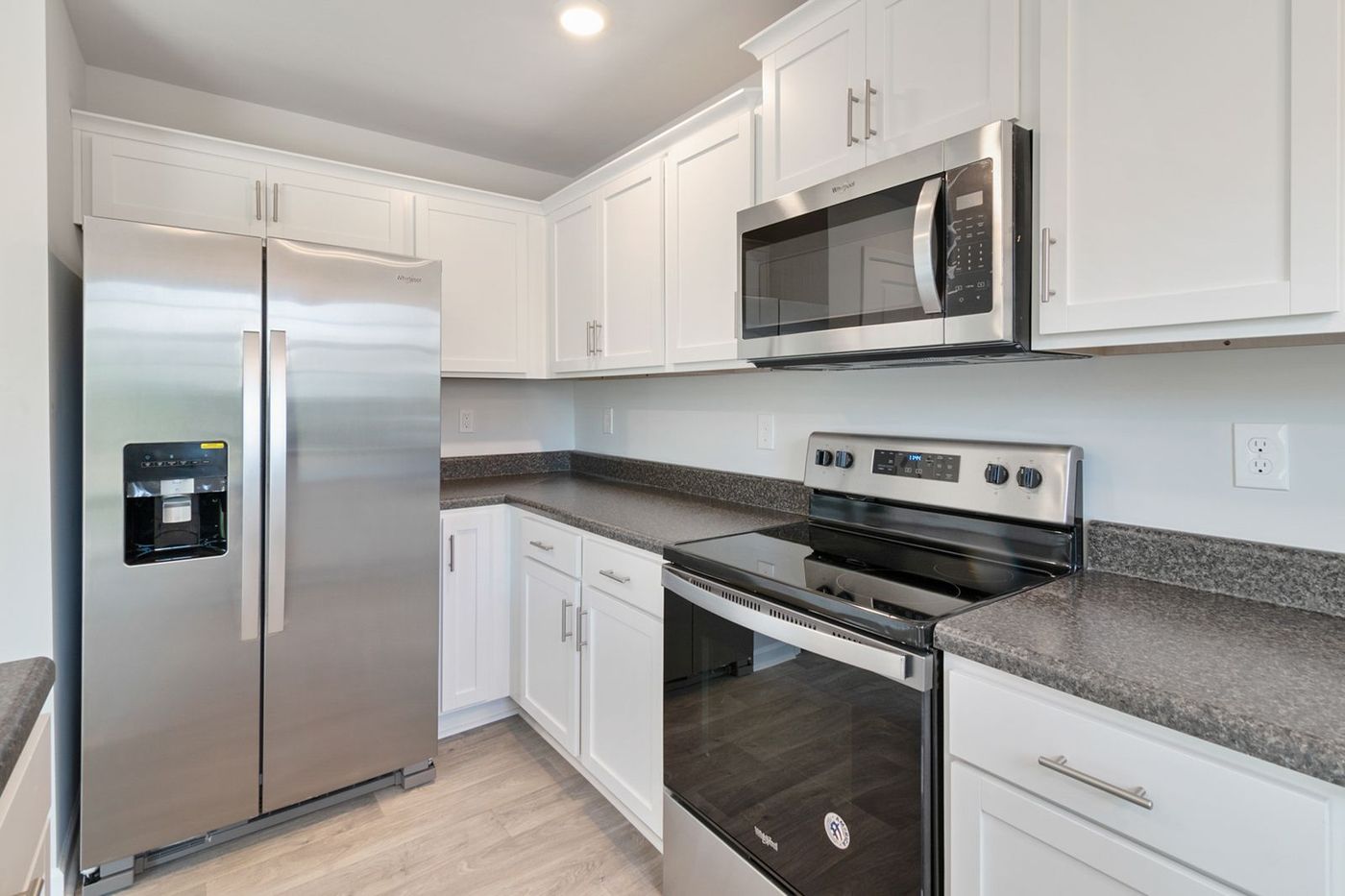 Bright kitchen with a stainless steel refrigerator, range and microwave