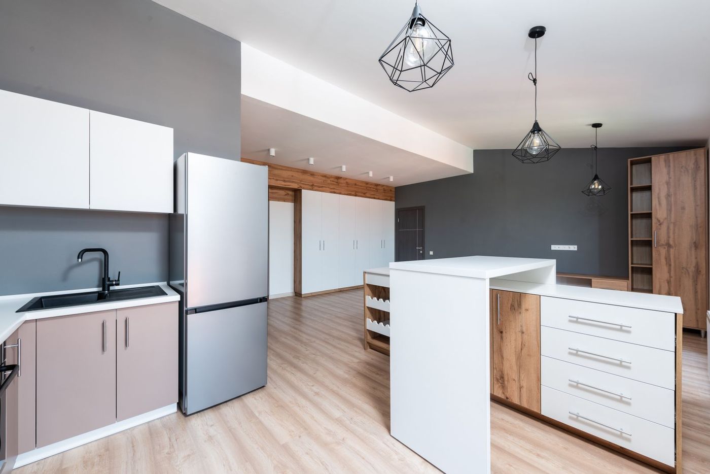 Modern open-plan kitchen with a stainless steel refrigerator